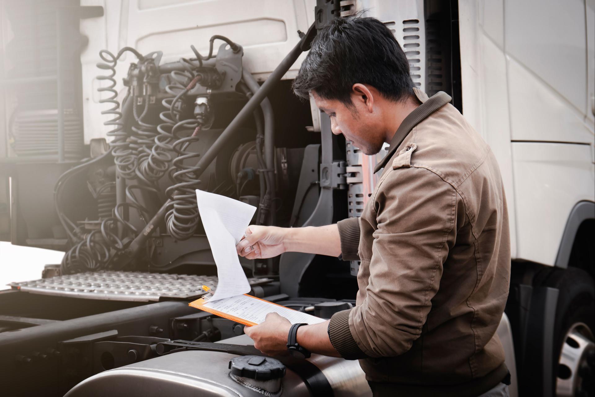 Truck Driver is Checking the Truck's Safety Maintenance Checklist. Lorry Fixing. Inspection Safety Trucks